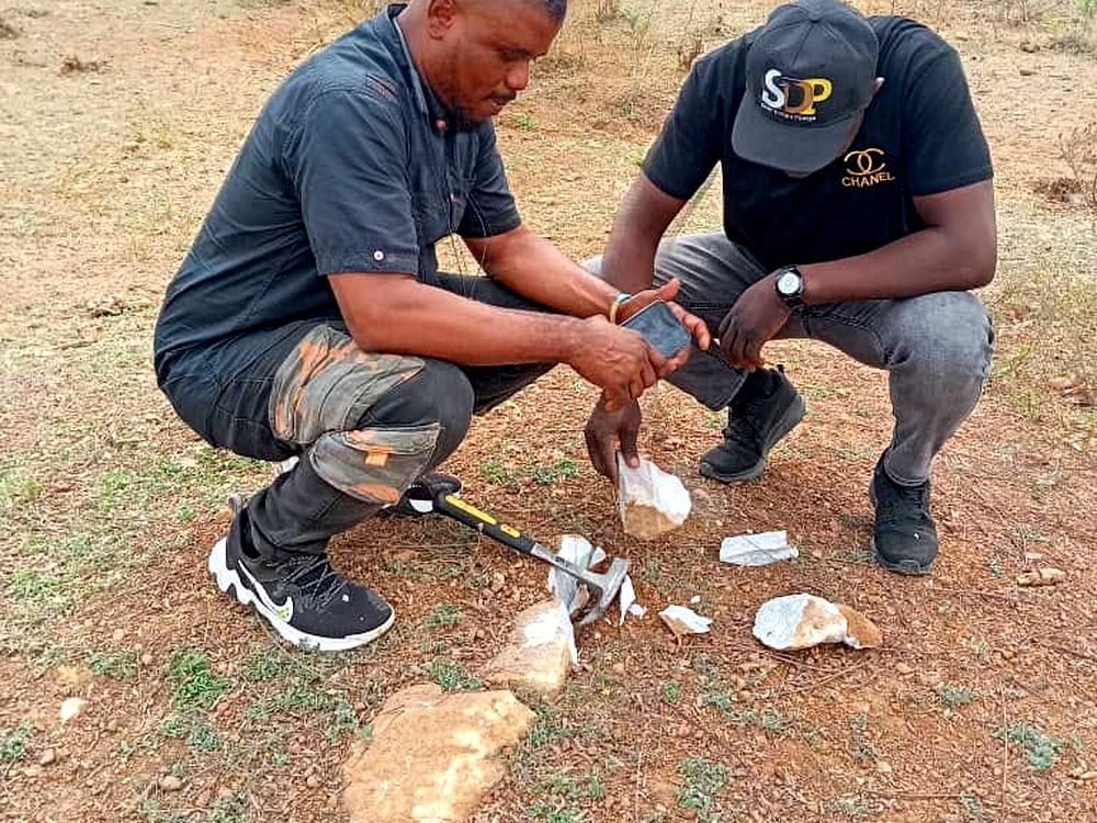 Dominion geologists examining rock samples during a field exploration programme