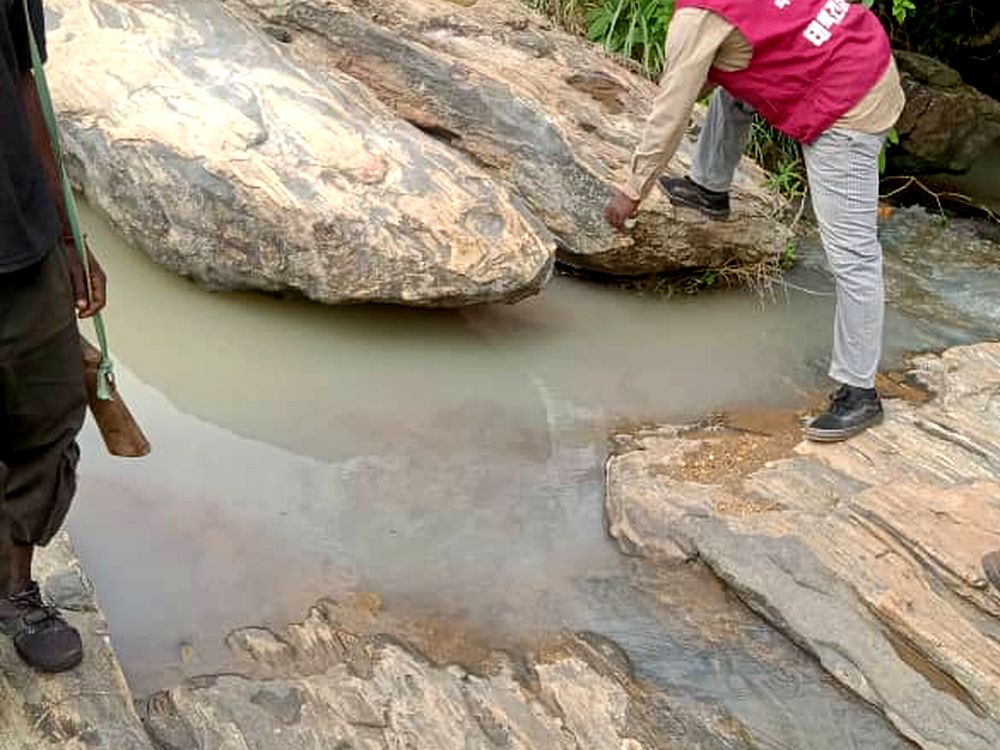 Team carrying out a stream survey over exposed bedrock during mineral exploration